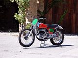 a red and green dirt bike parked on the side of the road