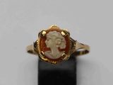 un gros plan sur une bague en or ornée du visage d'une femme