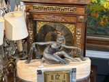 une horloge posée sur une table à côté d'un tableau