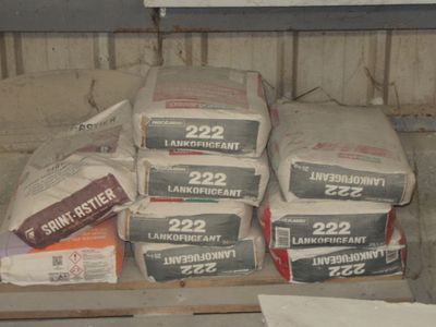 de nombreux cartons de ciment posés sur une étagère dans une pièce