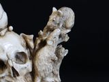 a statue of a skull with a bird on top of it