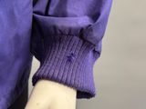 someone is holding a purple sweater with a purple ring on their finger
