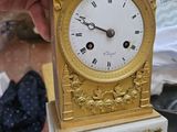 une personne tenant une petite montre en or dans la main