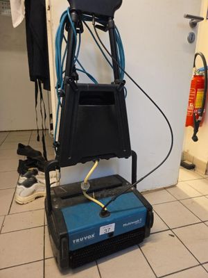 une photo d'une pièce avec un aspirateur posé par terre