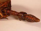 a wooden object with a metal handle on a white surface