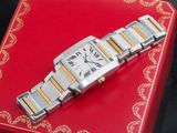 une photo d'une montre-bracelet argentée et dorée posée sur un coffret rouge
