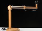 a wooden desk lamp on a white table with a black background