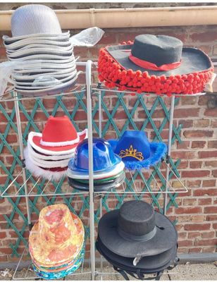 many hats that are sitting on a rack