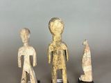 three carved figurines of a man, woman and child