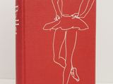 a red book with a drawing of a woman in a skirt