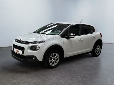 Une Citroën blanche est garée dans une pièce blanche