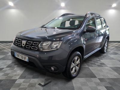 une photo d'une dacia grise garée sur un sol en damier