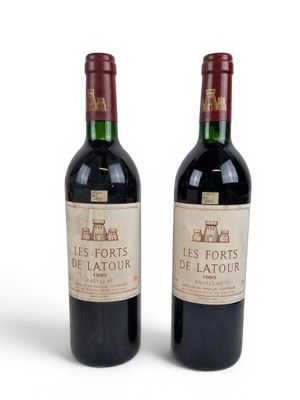 two bottles of red wine sitting next to each other on a white surface