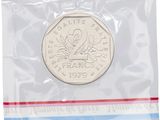 a close up of a coin in a plastic bag on a white background