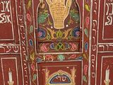 a red cabinet with a hand painted design on it