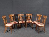 quatre chaises en bois avec des assises rembourrées à rayures dans une pièce