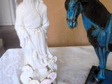 a statue of a man riding a horse next to a statue of a woman