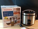 une boîte de nourriture posée sur une table à côté d'une mijoteuse
