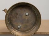 a brass plate with a bird on it sitting on a table