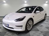 La Tesla Model 3 blanche est garée sur un sol à damier.