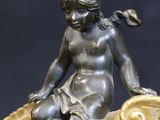 bronze statue of a girl sitting on a leaf with a bird on her shoulder
