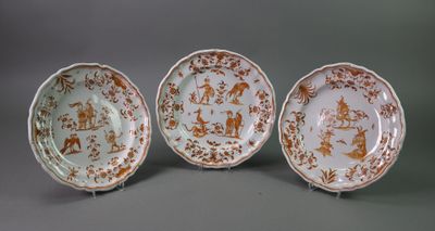 three plates with brown and white designs on them on a gray surface