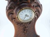 a wooden clock that is sitting on a white surface