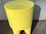 a yellow stool that is sitting on the ground