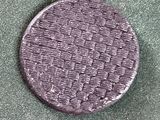 un gros plan d'un bouton violet sur une surface verte