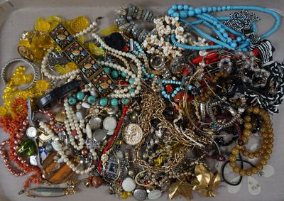 un plateau contenant un assortiment de colliers et de bracelets posé sur une table