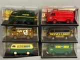four different types of toy trucks are displayed in a display case