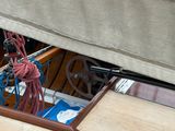a sail boat with a rope and a steering wheel on the deck