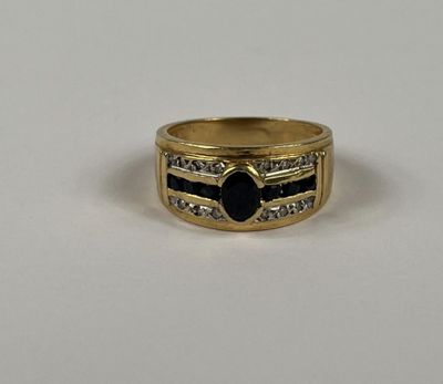 gros plan d'une bague en or avec une pierre noire