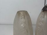 two glass vases sitting next to each other on a table