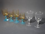 several different colored wine glasses are lined up on a gray surface