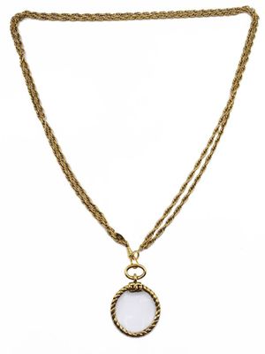 un collier en or avec un pendentif en pierre blanche monté sur une chaîne en or