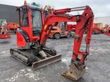 a red excavator that is parked in a parking lot