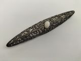 a close up of a hair clip with a pearl in it