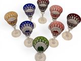six different colored glass goblets sitting on top of each other