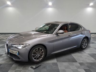 la voiture argentée est garée sur un sol en damier dans le garage