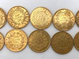un groupe de pièces d'or posées sur une surface blanche