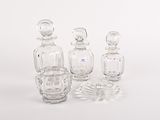trois flacons de parfum en verre transparent posés les uns à côté des autres sur une surface blanche