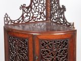 une armoire en bois dont le dessus est orné d'un motif sculpté
