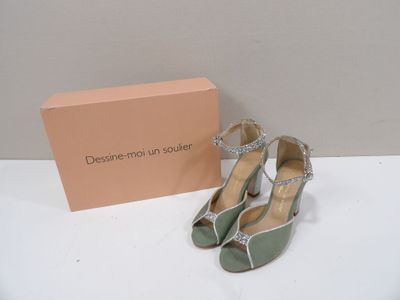une paire de chaussures vertes et argentées posée à côté d'une boîte rose