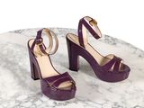 des sandales à talons hauts violettes posées sur une table en marbre, sur fond blanc