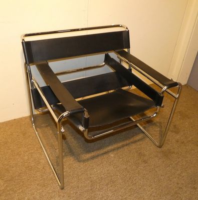 un fauteuil en cuir noir placé dans un coin de la pièce