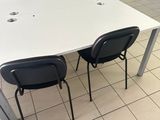 a white table with four black chairs in a room