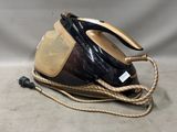 a black and gold steam iron sitting on a table
