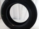 a close up of a tire on a white surface with a curtain in the background