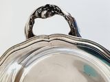 a silver plate with a handle on a table